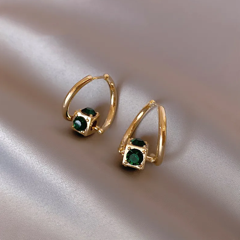 Elegant gold earrings with small dark green stones