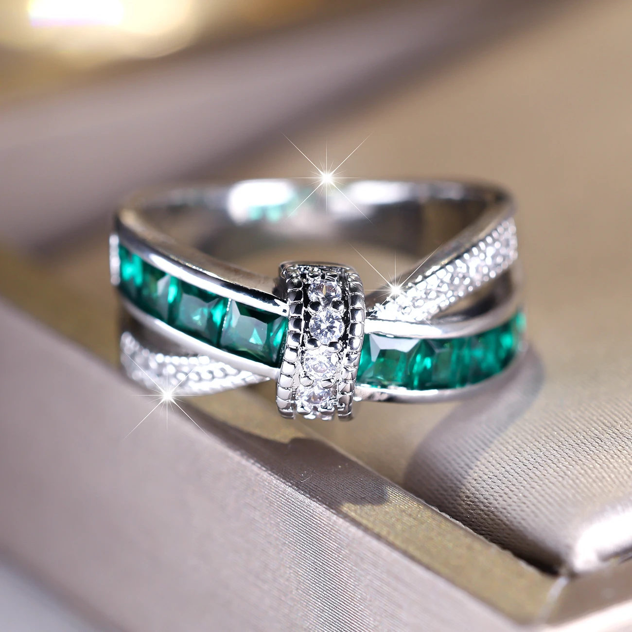 Silver ring crossed with green crystals